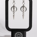 Midnight Spike crescent moon chainmail earrings displayed on earring stand by silentchxos