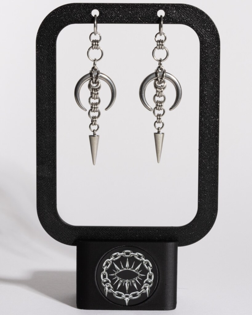 Midnight Spike crescent moon chainmail earrings displayed on earring stand by silentchxos