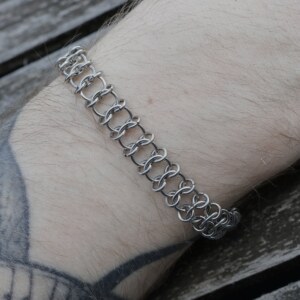 Close up shot of the Spine handmade chainmail bracelet in stainless steel worn on the arm by silentchxos