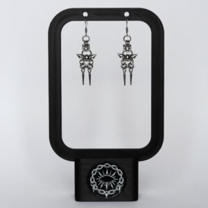 Handmade stainless steel chainmail earrings with a centre bead, side spikes and twin spike drops, displayed on a black earring stand against a light background.